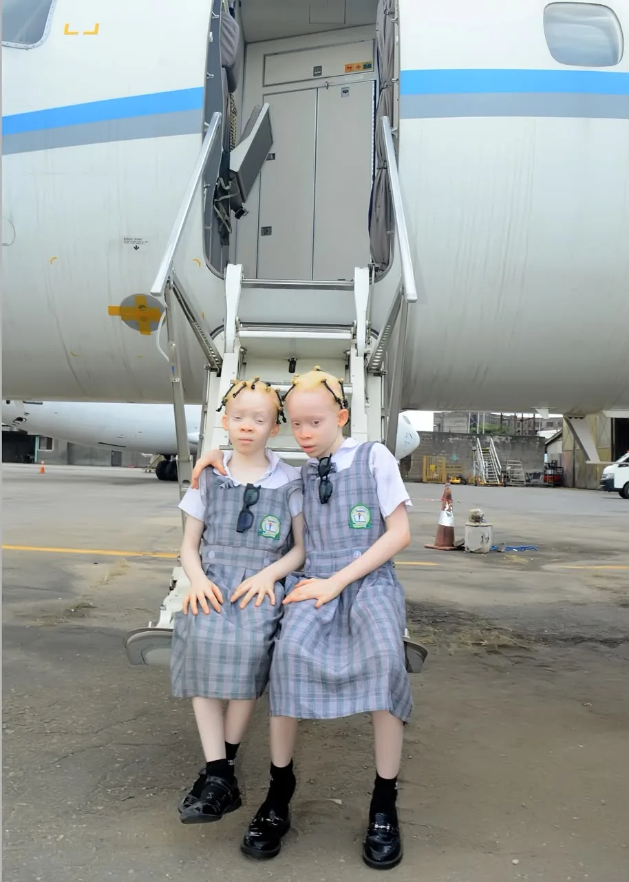 Two pupils sitting together on an aircraft airstair