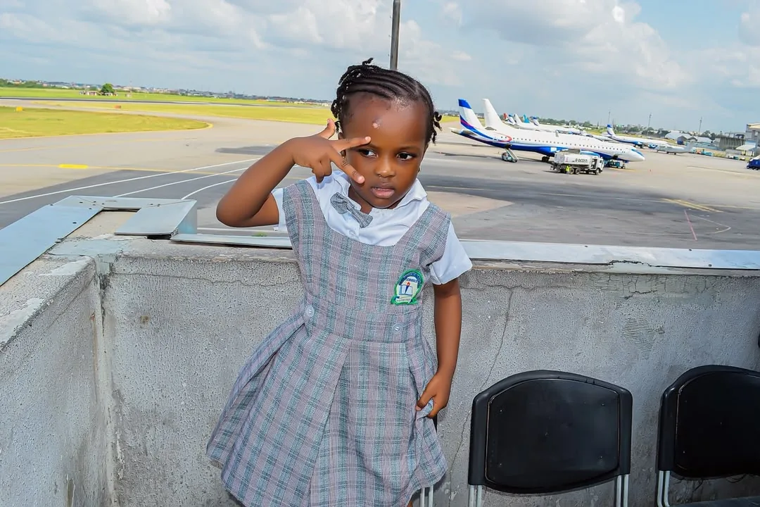 A nursery pupil on an airport viewing deck with aircraft lined up behind her
